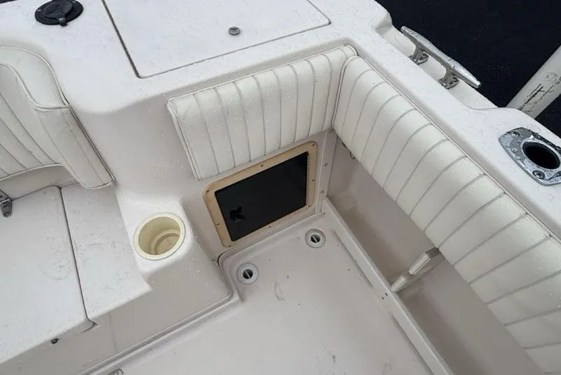 Slide: The Image of 1999 Grady-White Gulfstream 232 boat interior with white cushioned seating and storage compartment. - 15