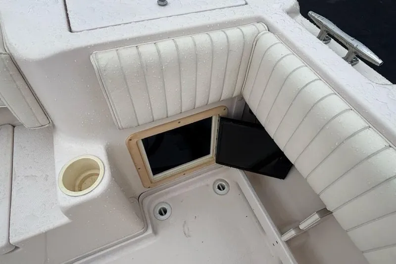 Slide: The Image of 1999 Grady-White Gulfstream 232 boat interior with cushioned seating and storage compartment. - 6