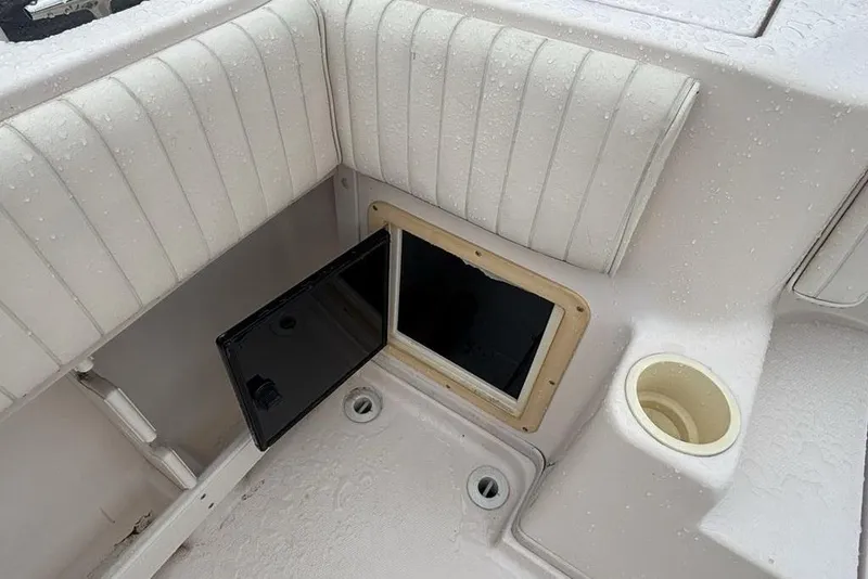 Slide: The Image of 1999 Grady-White Gulfstream 232 boat interior with open storage compartment and cup holder. - 10