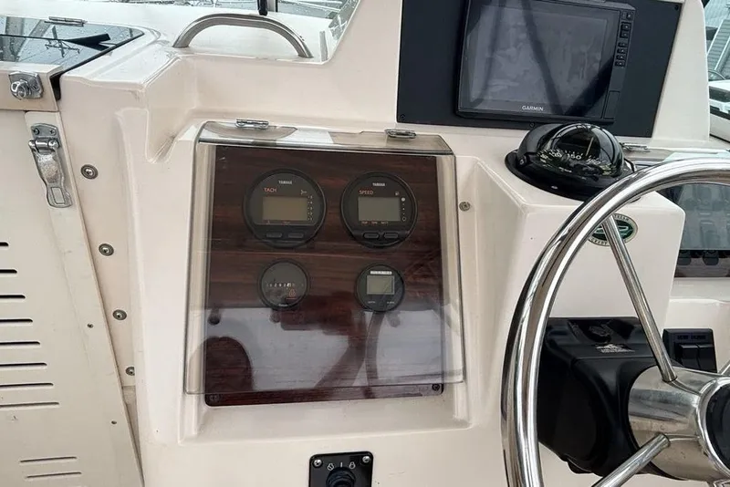 Slide: The Image of 1999 Grady-White Gulfstream 232 dashboard with gauges, compass, and Garmin display. - 14