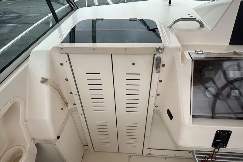 Slide: The Image of 1999 Grady-White Gulfstream 232 boat interior with control panel and storage compartment. - 13