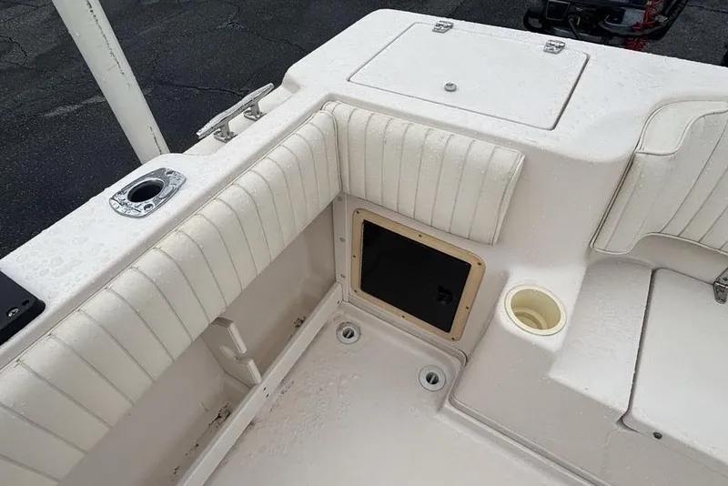Slide: The Image of 1999 Grady-White Gulfstream 232 boat interior with white cushioned seating and storage compartment. - 7