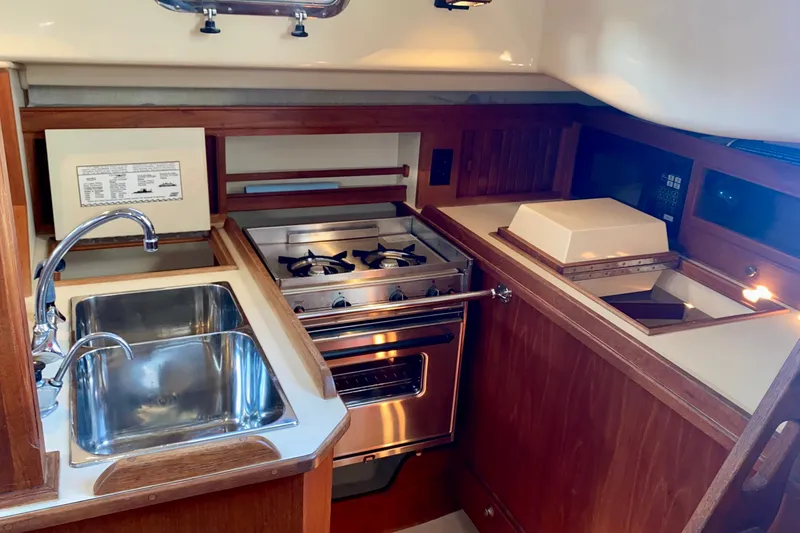 Slide: The Image of Galley showing Double SS Sink, Larder, Stove, and Refrigerator/Freezer. - 13