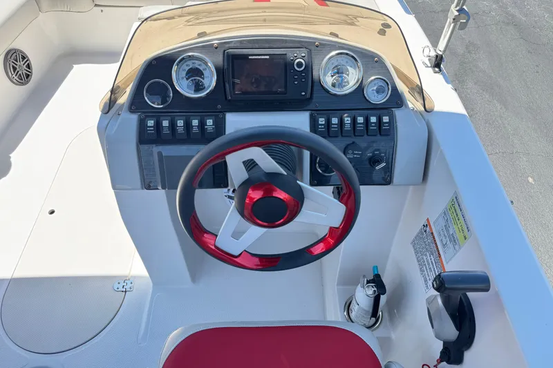 Slide: The Image of 2021 Starcraft MDX 211 O/B boat dashboard with red steering wheel and control panel. - 29