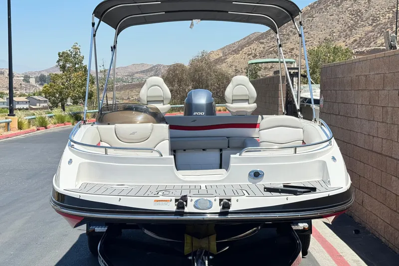 Slide: The Image of 2021 Starcraft MDX 211 O/B boat with canopy, parked on a sunny day. - 2