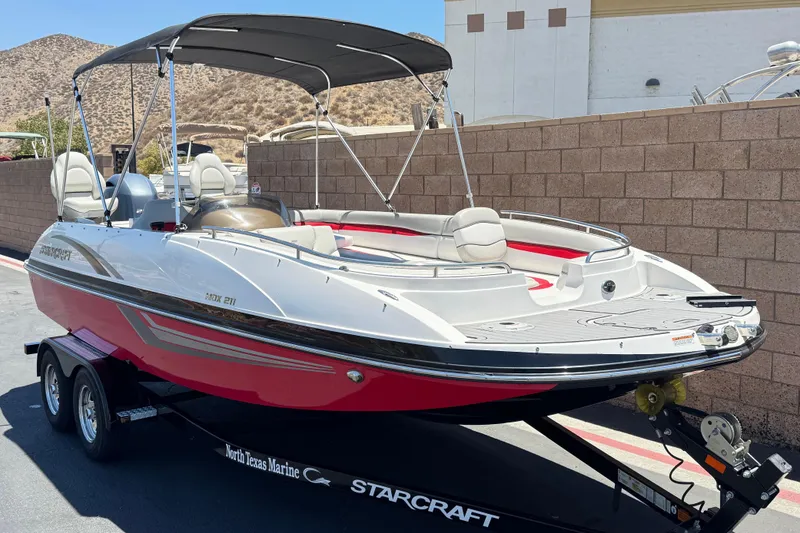 Slide: The Image of 2021 Starcraft MDX 211 O/B boat on trailer, featuring sleek design and canopy. - 1