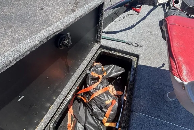 Slide: The Image of Storage compartment in a 1996 Javelin 369 SDC boat with red seat and gear bag. - 10