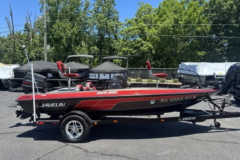 The Image of Red and black 1996 Javelin 369 SDC boat on trailer, parked outdoors. - 1