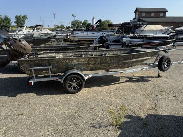 The Image of A War Eagle 648LDV boat on a trailer, surrounded by other boats in a parking lot. - 1