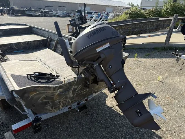 Slide: The Image of A War Eagle 648LDV boat with a Yamaha outboard motor, parked on a trailer in a gravel lot. - 7