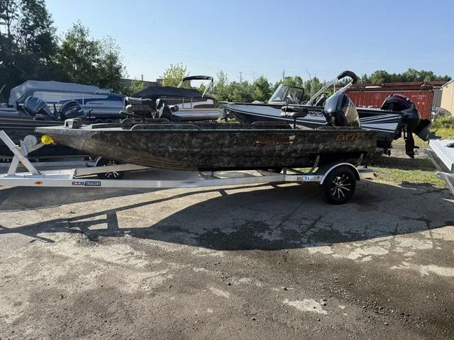 The Image of An Excel Tomahawk 183 T boat from 2026 on a trailer, surrounded by other boats outdoors. - 1