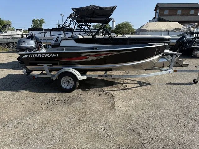 The Image of A 2027 Starcraft Seafarer DLX 14 on a trailer. It features a black design with a sunshade. - 1