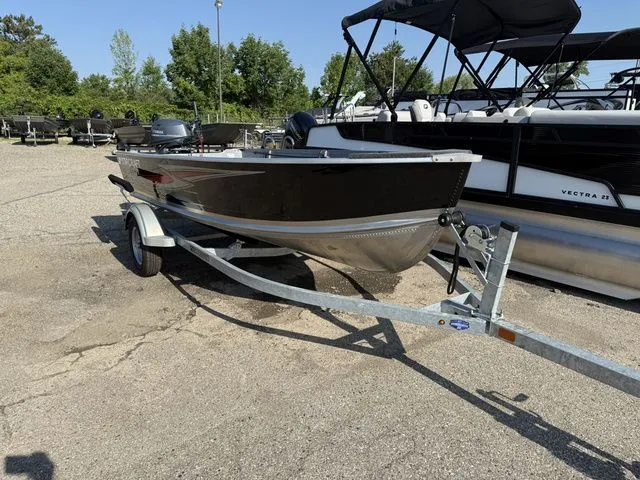 Slide: The Image of A 2027 Starcraft Seafarer DLX 14 boat on a trailer in a parking lot. - 2