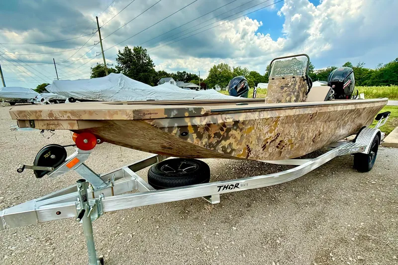 The Image of 2027 Thor LAKE HAMMER 1900 CC boat on trailer, camo design, parked outdoors. - 1
