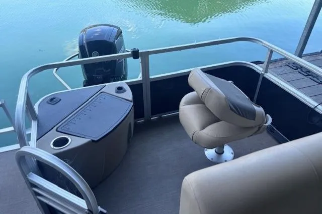 Slide: The Image of 2020 Sun Tracker Fishin' Barge 20 DLX pontoon boat with seating and motor, docked on calm water. - 3