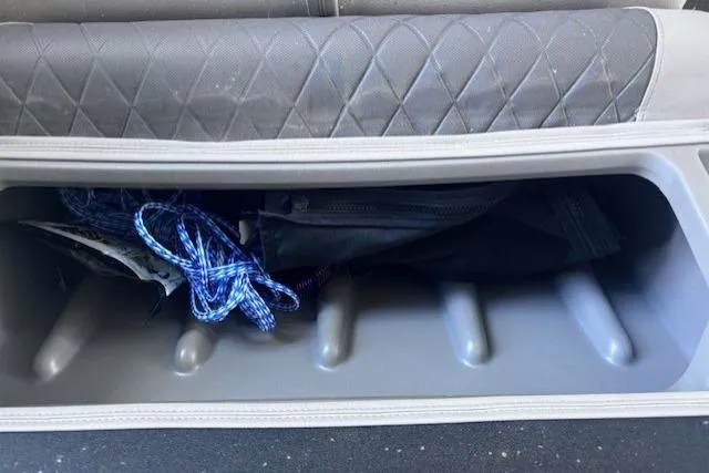 Slide: The Image of Storage compartment in a 2020 Sun Tracker Fishin' Barge 20 DLX with blue rope inside. - 18