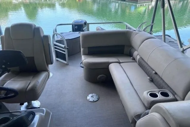 Slide: The Image of 2020 Sun Tracker Fishin' Barge 20 DLX interior with seating and lake view. - 4