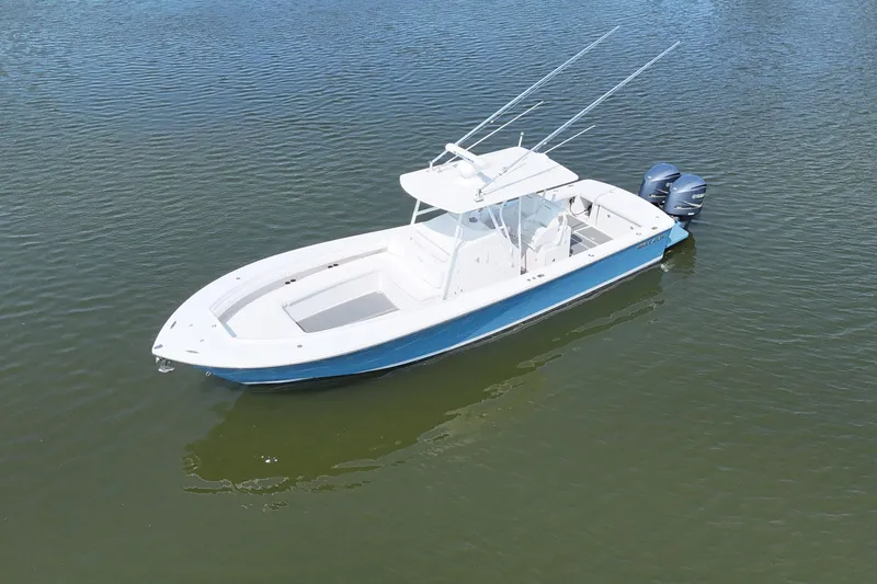 Slide: The Image of A 2010 Regulator 34SS floats on calm water. It features an open deck and twin outboard engines. - 5