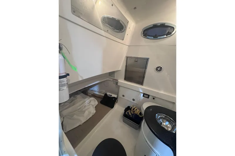Slide: The Image of 2010 Regulator 34SS cabin interior with bed, storage, and portholes. - 32