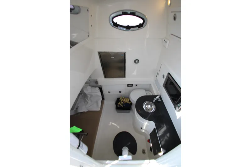 Slide: The Image of Interior of a 2010 Regulator 34SS featuring a sink, toilet, and storage space. - 30