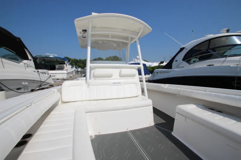 Slide: The Image of A 2010 Regulator 34SS with white seating area and T-top, surrounded by other boats in the marina. - 16