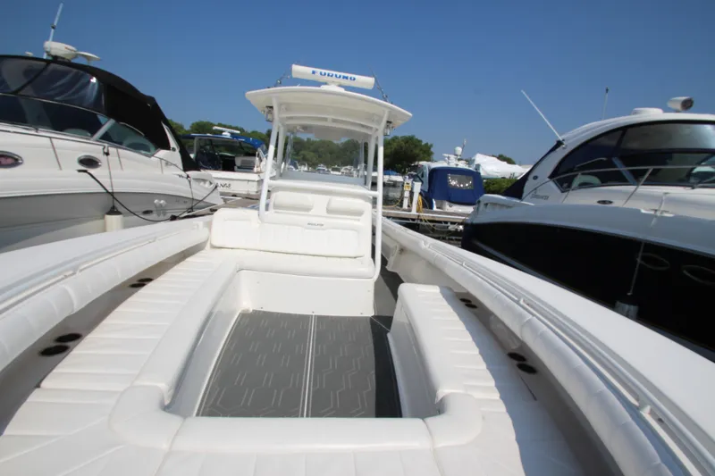 Slide: The Image of A 2010 Regulator 34SS with white interior and gray flooring, surrounded by other boats in a marina. - 15