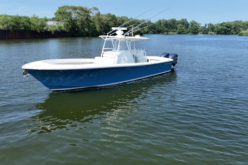 Slide: The Image of A blue and white 2010 Regulator 34SS floats on calm water, surrounded by trees. - 3