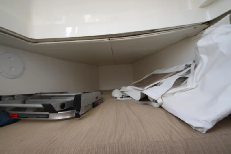 Slide: The Image of A storage compartment inside a boat with a ladder and a tarp. - 35