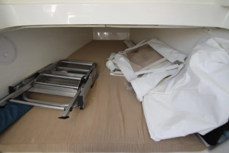 Slide: The Image of A storage compartment with a ladder and folded tarps on a boat. - 34