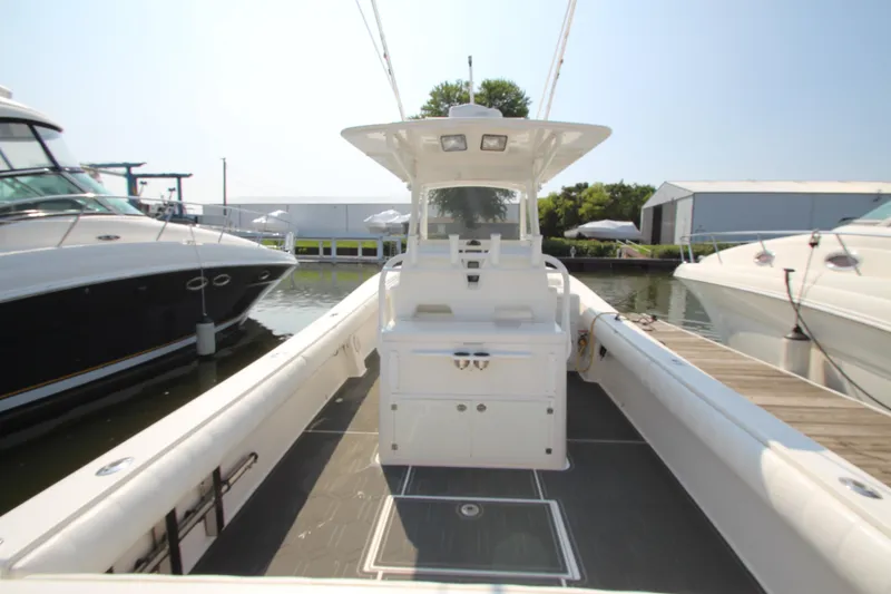 Slide: The Image of A 2010 Regulator 34SS boat docked. It features a spacious deck and a central helm console. - 23