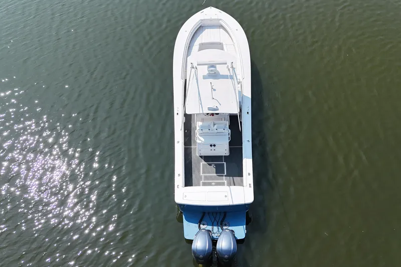 Slide: The Image of Aerial view of a white 2010 Regulator 34SS boat on calm water with twin outboard engines. - 6