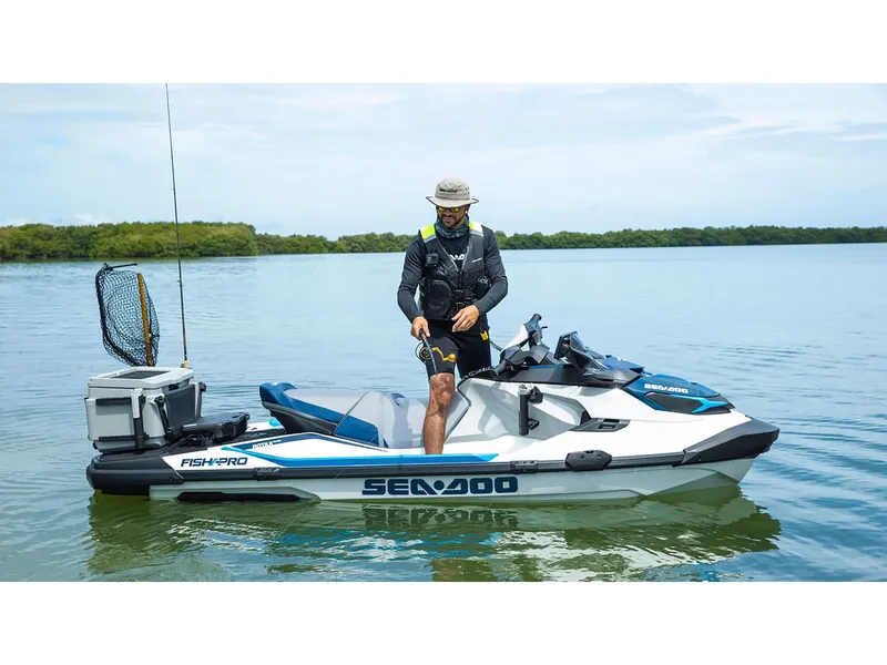 Slide: The Image of A man stands on a Sea-Doo FishPro Sport 170 jet ski on calm water. - 8