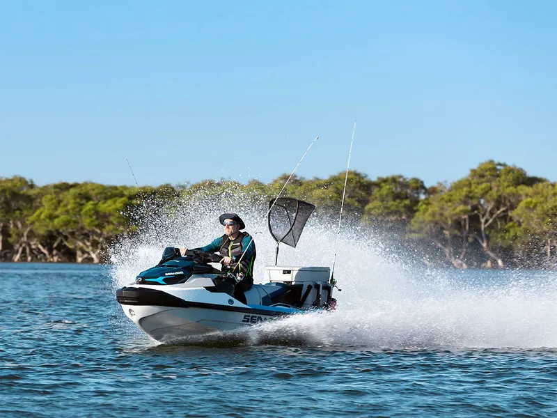 Slide: The Image of A 2024 Sea-Doo FishPro Sport 170 iDF iBR speeds across the water, surrounded by trees. - 9