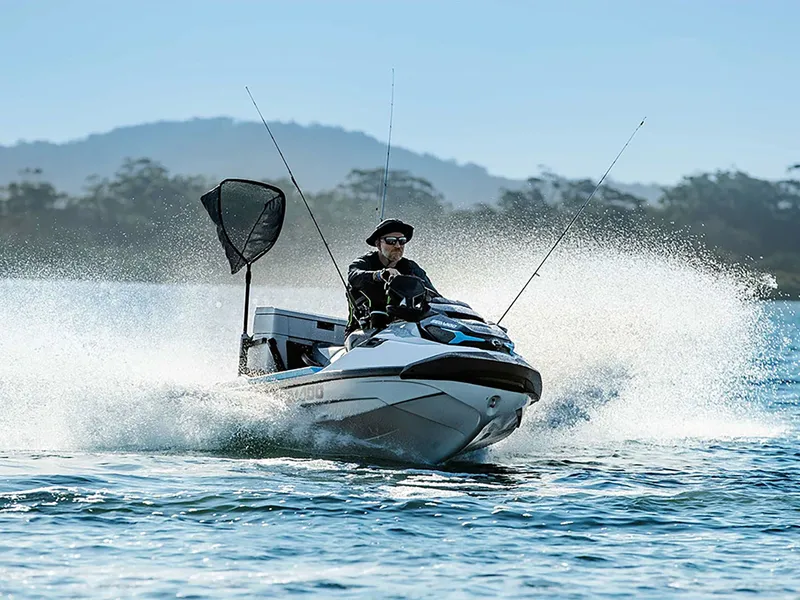 Slide: The Image of A 2024 Sea-Doo FishPro Sport 170 speeds across the water, equipped with fishing rods and gear. - 6