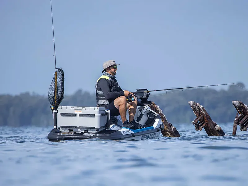 Slide: The Image of A man fishing on a Sea-Doo FishPro Sport 170. He sits on the watercraft with fishing gear. - 7