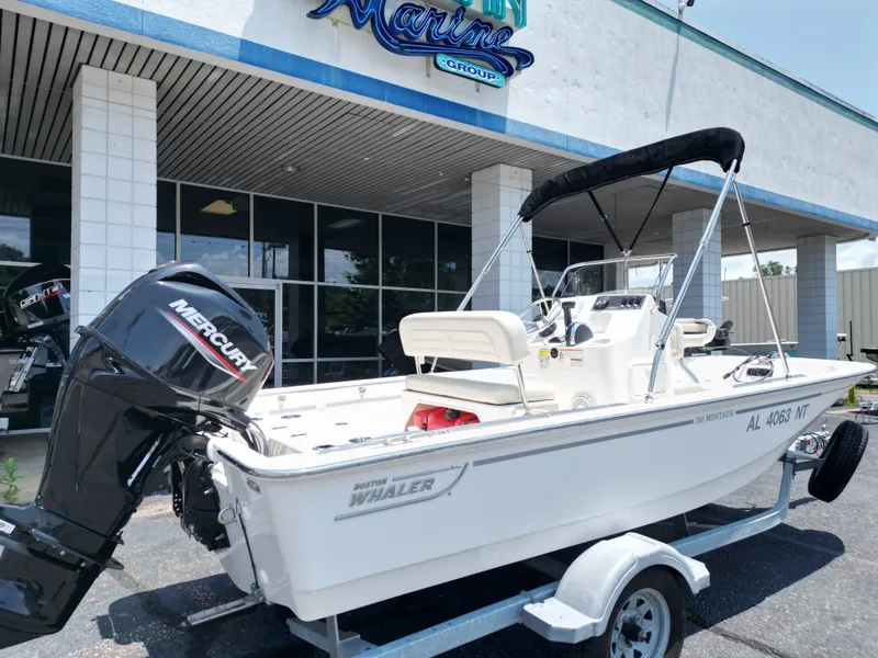 Slide: The Image of A 2023 Boston Whaler 150 Montauk on a trailer outside a building. - 16