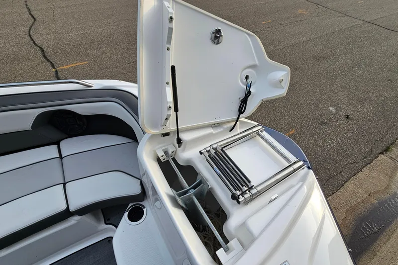 Slide: The Image of 2019 Yamaha Boats 212 Limited with open storage compartment and seating area. - 19