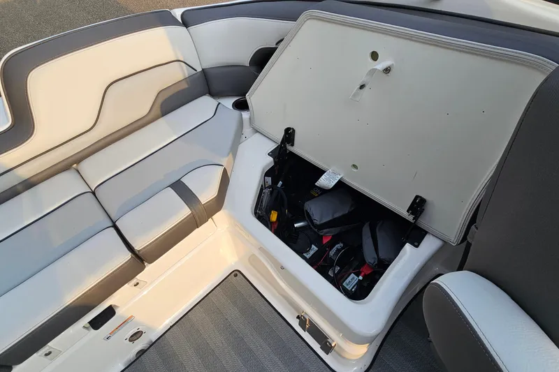 Slide: The Image of 2019 Yamaha Boats 212 Limited interior with open storage compartment, showcasing seating and equipment. - 22