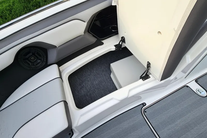 Slide: The Image of 2019 Yamaha Boats 212 Limited interior storage compartment with cushioned seating and speaker. - 26
