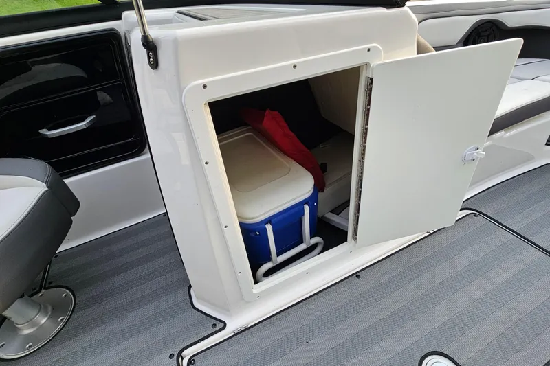 Slide: The Image of 2019 Yamaha Boats 212 Limited storage compartment with cooler and red bag inside. - 24