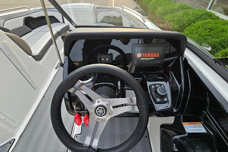 Slide: The Image of 2019 Yamaha Boats 212 Limited dashboard with steering wheel and digital display. - 14