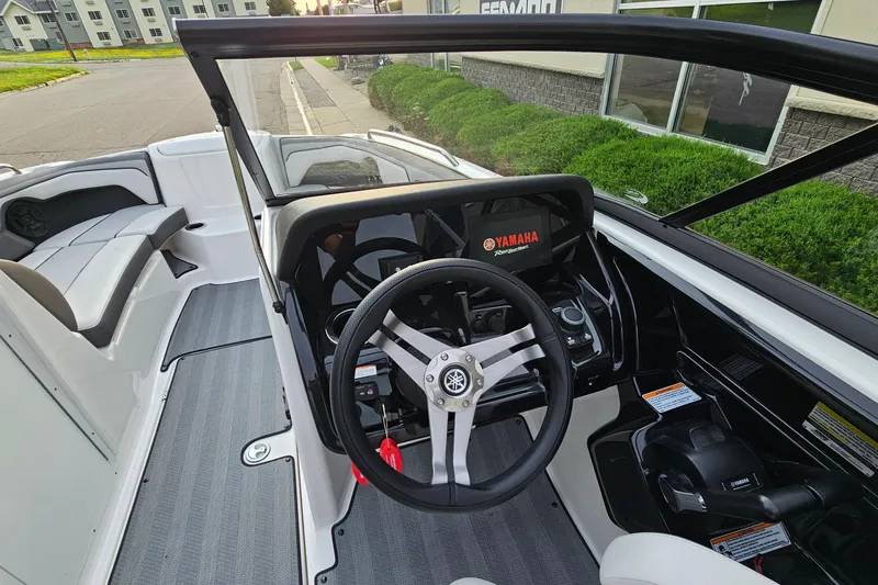 Slide: The Image of Interior view of 2019 Yamaha Boats 212 Limited, showcasing steering wheel and dashboard controls. - 13