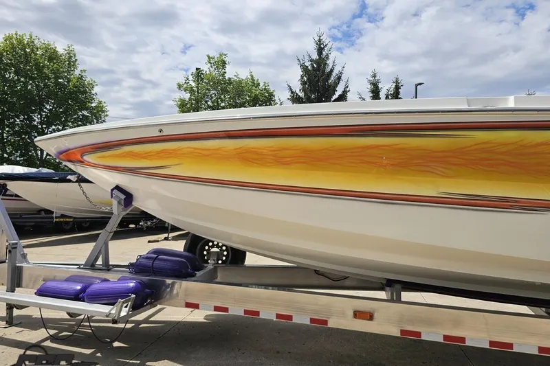 Slide: The Image of 2002 Cigarette 42' Tiger boat with vibrant flame design on trailer. - 22