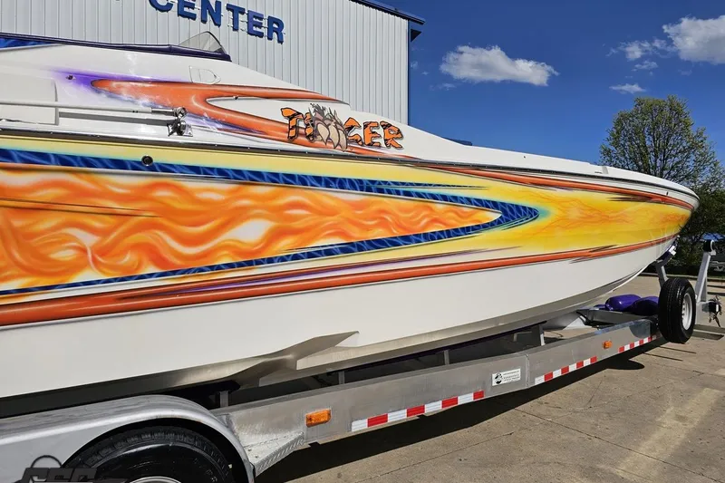 Slide: The Image of 2002 Cigarette 42' Tiger boat with vibrant flame graphics on trailer. - 8