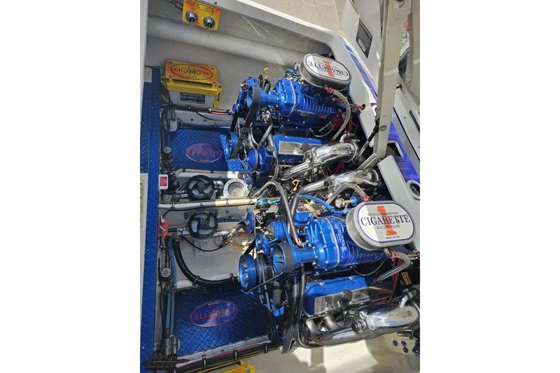 Slide: The Image of Engine compartment of a 2002 Cigarette 42' Tiger boat, featuring dual blue engines. - 99