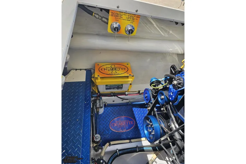Slide: The Image of Engine compartment of a 2002 Cigarette 42' Tiger boat, featuring branded components and blue accents. - 100