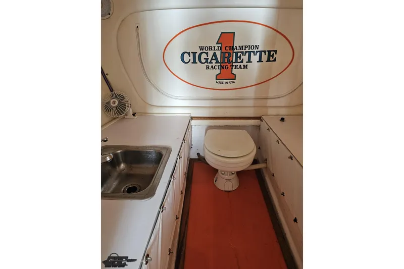 Slide: The Image of Interior of 2002 Cigarette 42' Tiger boat with sink and toilet, showcasing racing team logo. - 84