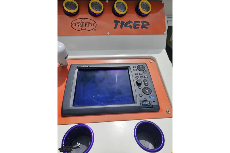 Slide: The Image of Control panel of a 2002 Cigarette 42' Tiger boat with gauges and navigation screen. - 61