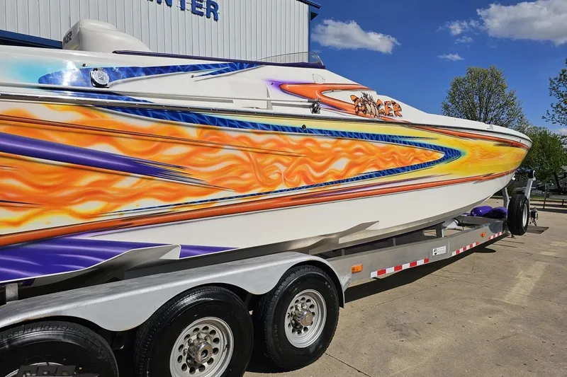 Slide: The Image of 2002 Cigarette 42' Tiger boat with vibrant flame graphics on a trailer. - 9
