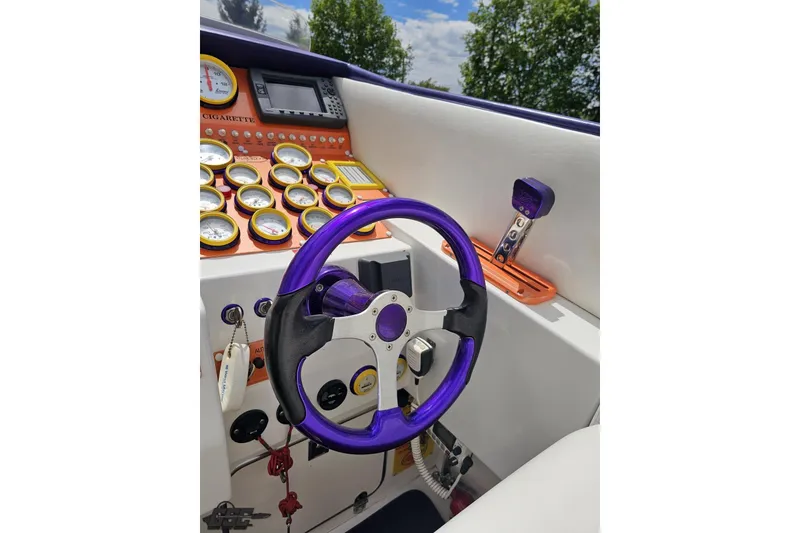 Slide: The Image of Cockpit of 2002 Cigarette 42' Tiger boat with purple steering wheel and gauges. - 65